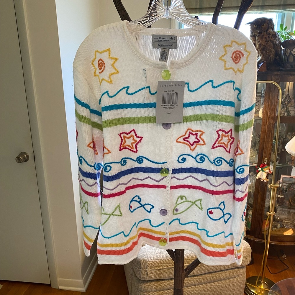 White cardigan with embroidered yarn stitching fish stars water and swirls. L.